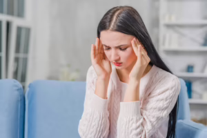 Young woman holding her head experiencing headache pain