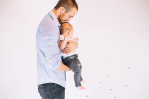 Parent carrying a baby while experiencing back or neck strain