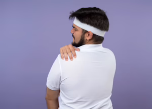 Person massaging the upper back between the shoulder blades due to muscle tension
