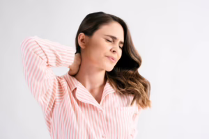 Person holding neck due to ongoing pain and stiffness